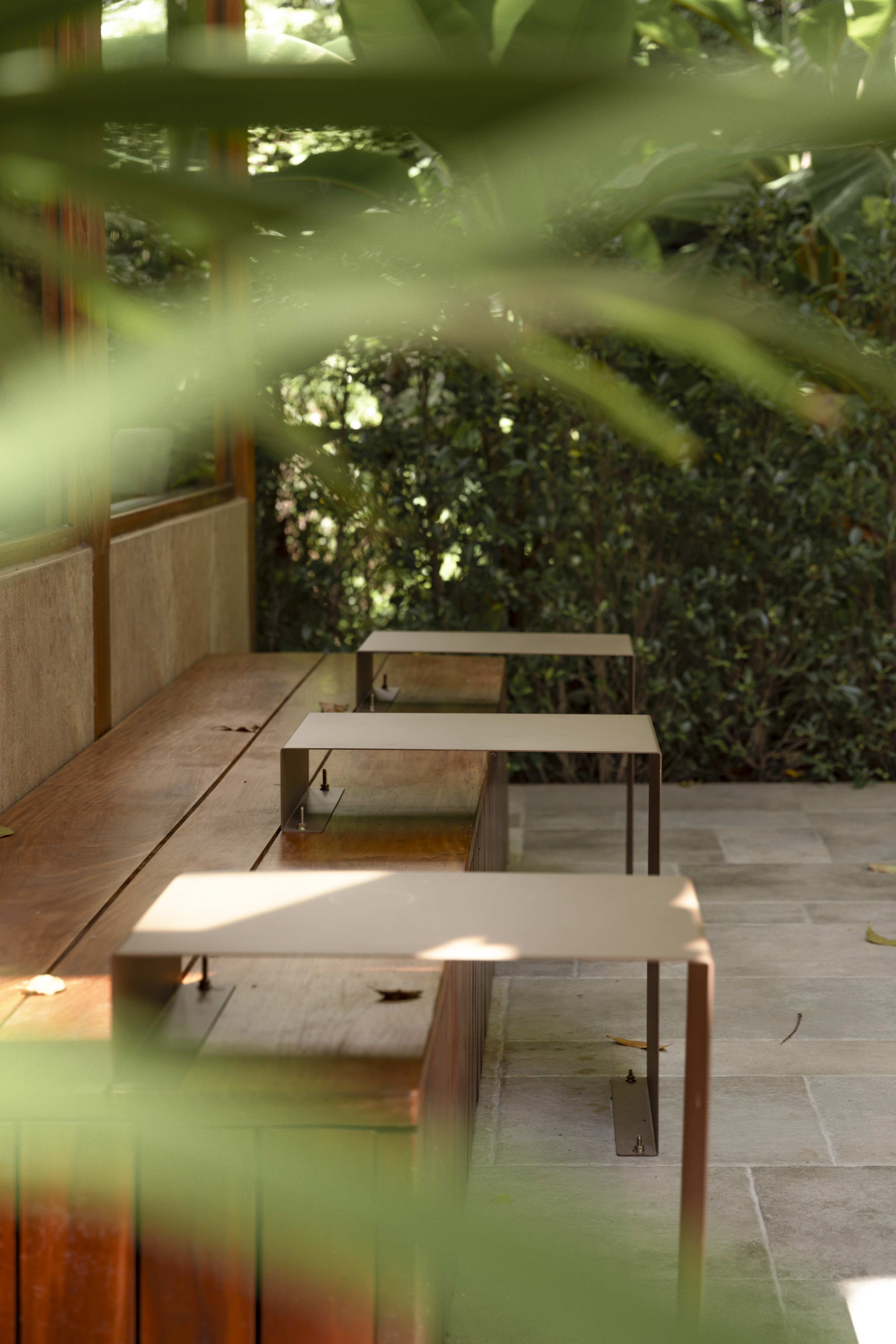 Café LOM outdoor garden seating seen through foliage