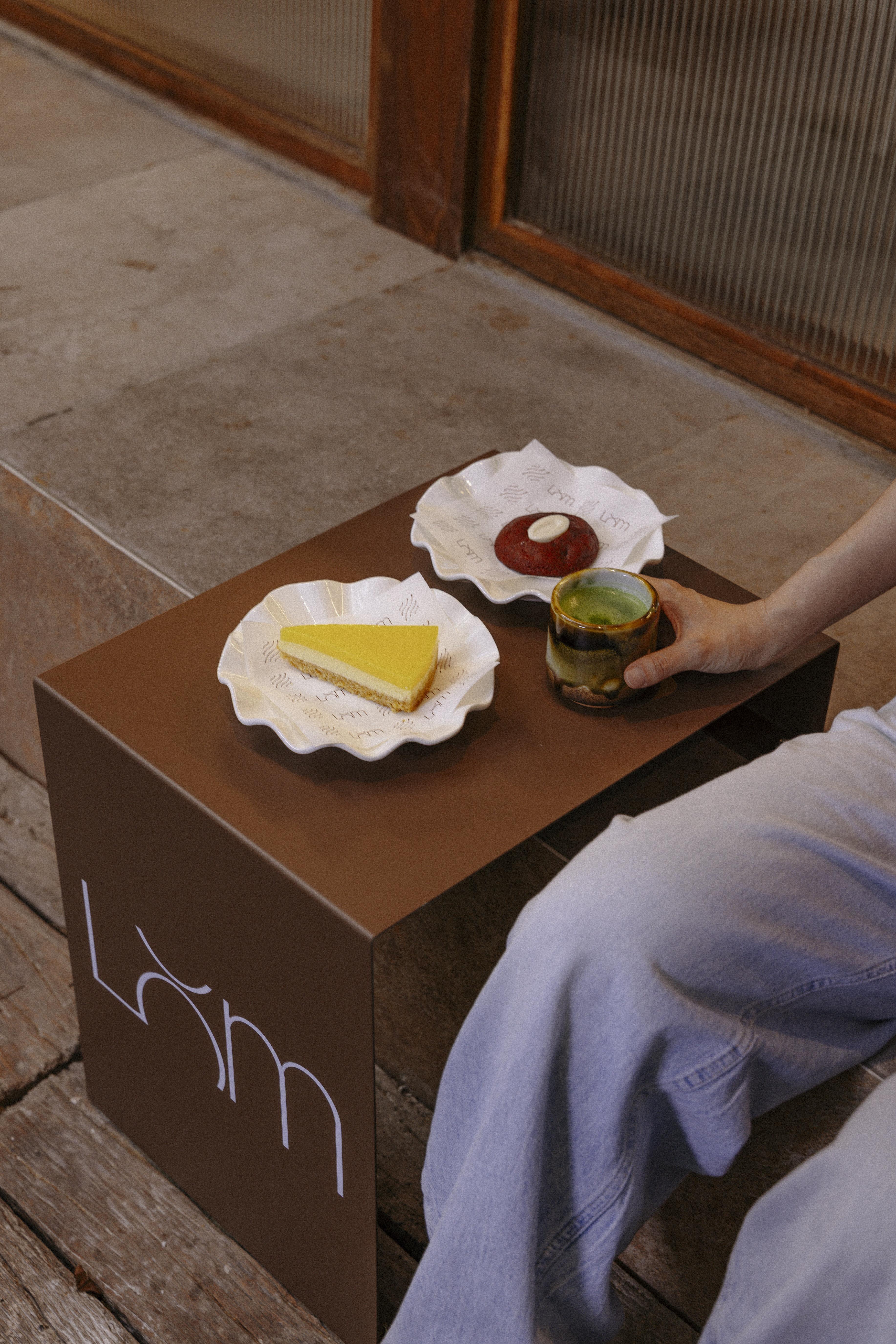 Café LOM homemade desserts — cheesecake and tart on the LOM-branded table